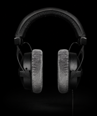 Black over-ear headphones with textured gray ear cushions, shown from the front against a solid black background.