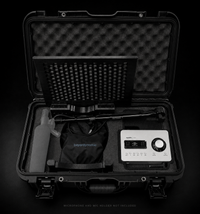 An open black hard carrying case displaying a microphone, set against a solid black background.
